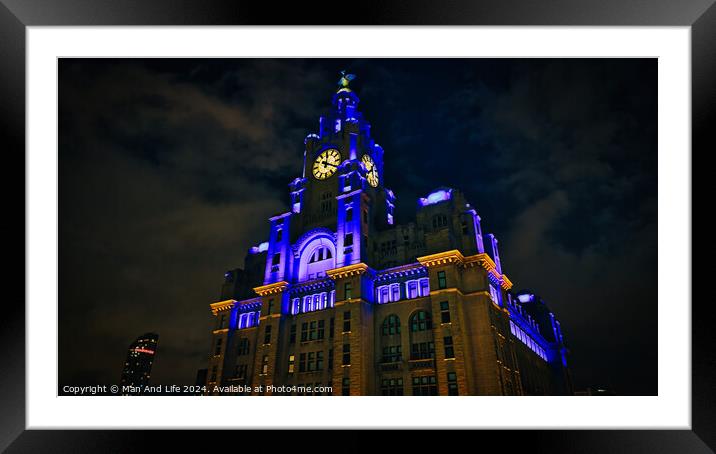 Liverpool's iconic Royal Liver Building at night, illuminated with blue and yellow lights against a dark sky. Framed Mounted Print by Man And Life