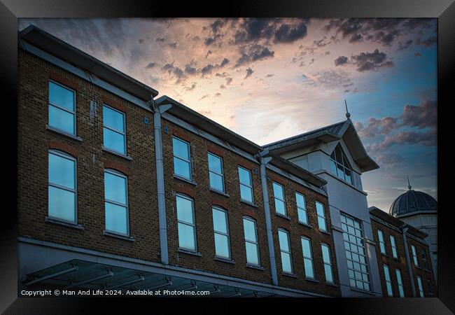 Classic building facade against a dramatic sunset sky with clouds. Framed Print by Man And Life