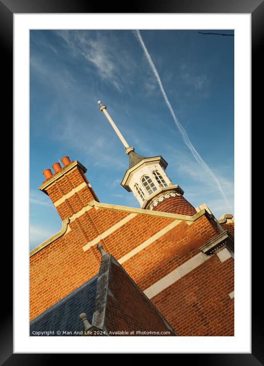 Historic brick building with a distinctive cupola against a blue sky with contrails. Framed Mounted Print by Man And Life