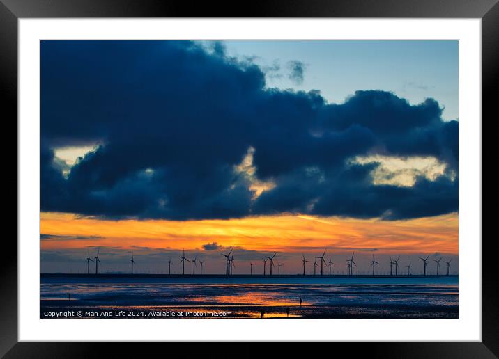 Sunset over sea with silhouette of offshore wind turbines, vibrant sky, and reflection on water in Crosby, England. Framed Mounted Print by Man And Life