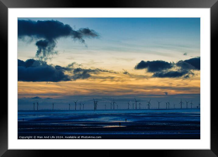 Serene sunset over a wind farm with silhouettes of turbines and dramatic clouds, reflecting on water in Crosby, England. Framed Mounted Print by Man And Life