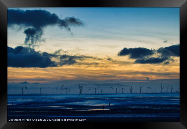 Serene sunset over a wind farm with silhouettes of turbines and dramatic clouds, reflecting on water in Crosby, England. Framed Print by Man And Life