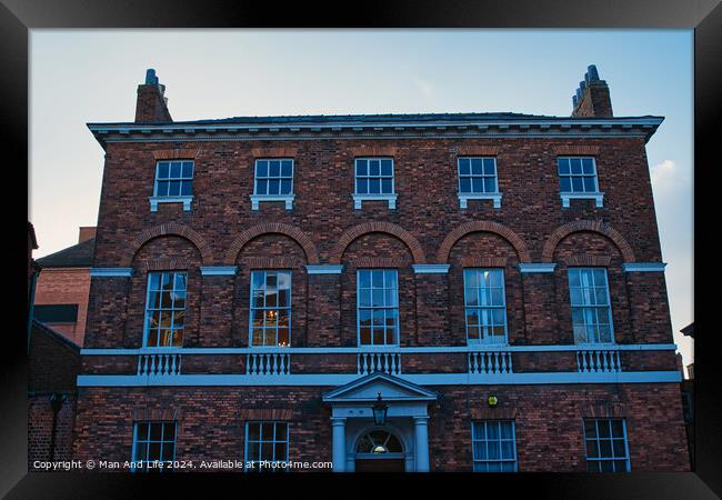 Traditional brick building facade under blue sky at dusk in York, UK. Framed Print by Man And Life