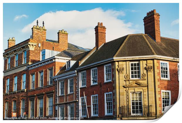 Historic brick buildings with classic British architecture under a clear blue sky in York, UK. Print by Man And Life