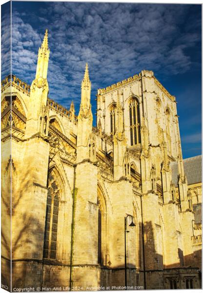 Gothic cathedral facade with spires against a clear blue sky at sunset, showcasing historical architecture in York, UK. Canvas Print by Man And Life
