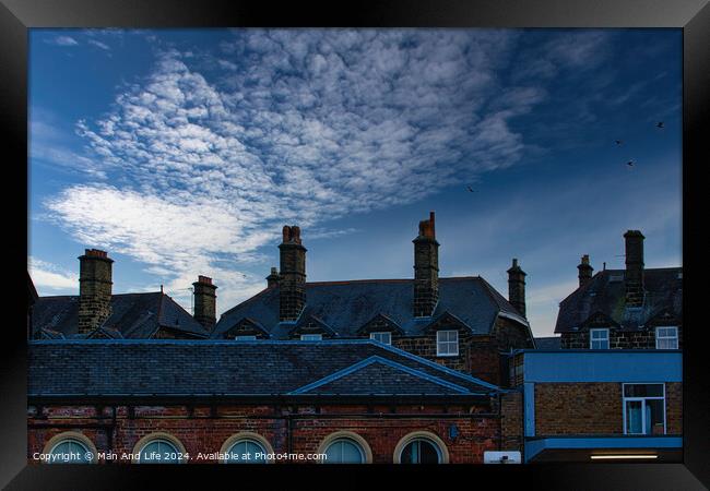 Dramatic sky over silhouette of traditional buildings with distinctive chimneys at dusk in Harrogate, England. Framed Print by Man And Life