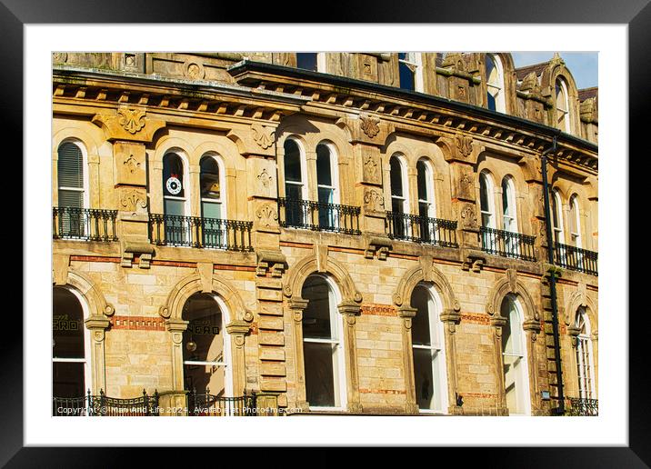 Vintage brick building facade with ornate windows and architectural details under a clear blue sky in Harrogate, England. Framed Mounted Print by Man And Life