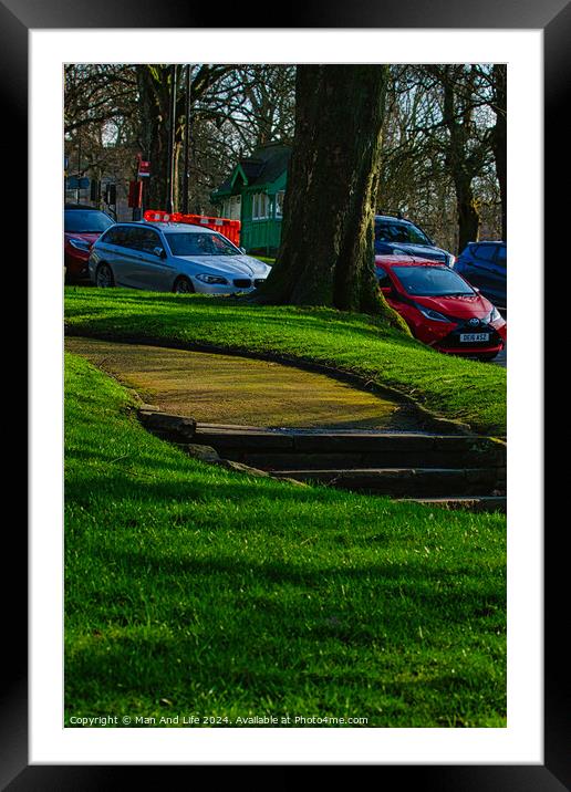 Sunny park with green grass and a pathway leading through trees, with parked cars in the background in Harrogate, England. Framed Mounted Print by Man And Life