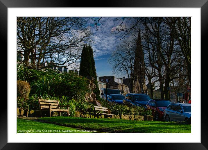 Tranquil urban park scene with benches and lush greenery, set against a backdrop of historic buildings and blue sky with wispy clouds in Harrogate, England. Framed Mounted Print by Man And Life