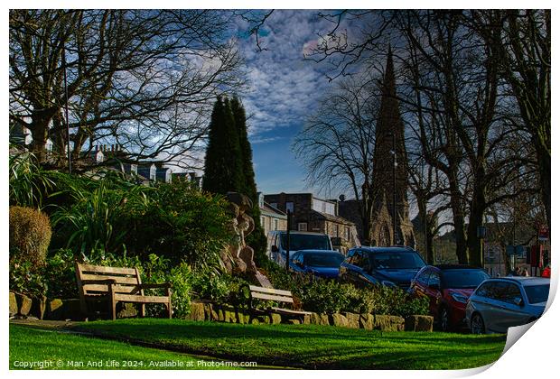 Tranquil urban park scene with benches and lush greenery, set against a backdrop of historic buildings and blue sky with wispy clouds in Harrogate, England. Print by Man And Life