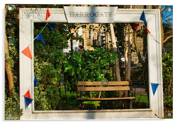 Quaint garden scene framed by a white wooden structure with 'Harrogate' sign, featuring a bench and lush greenery, adorned with colorful pennants. Acrylic by Man And Life