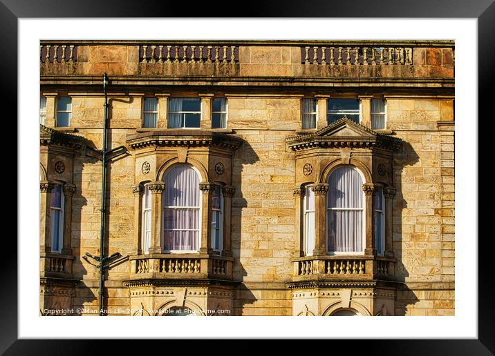 Close-up of a classic sandstone building facade with ornate windows and architectural details in warm sunlight in Harrogate, England. Framed Mounted Print by Man And Life