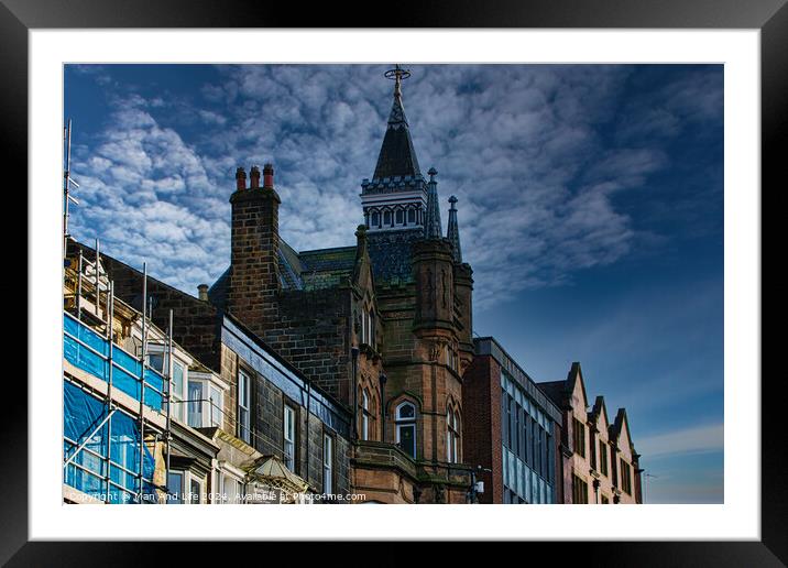 Historic architecture with a spire against a dramatic sky, flanked by modern buildings and scaffolding in Harrogate, England. Framed Mounted Print by Man And Life