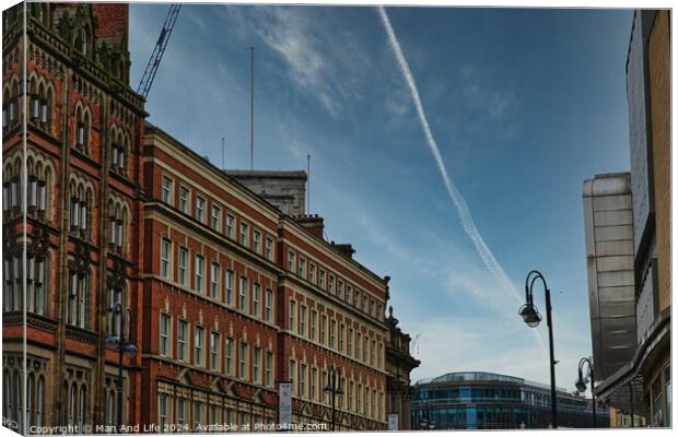 Urban street view with historic buildings under a clear blue sky with contrails in Leeds, UK. Canvas Print by Man And Life