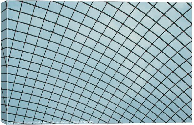 Abstract geometric pattern of a glass ceiling against a clear blue sky. Canvas Print by Man And Life