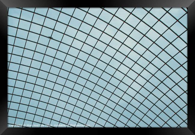 Abstract geometric pattern of a glass ceiling against a clear blue sky. Framed Print by Man And Life