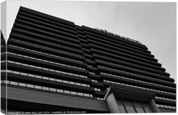 Modern black and white architectural photograph of a high-rise building with a patterned facade against a cloudy sky in Leeds, UK. Canvas Print by Man And Life