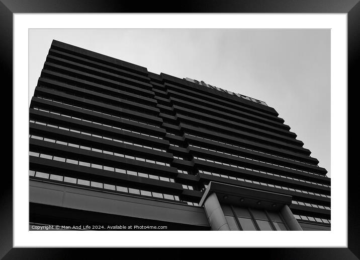 Modern black and white architectural photograph of a high-rise building with a patterned facade against a cloudy sky in Leeds, UK. Framed Mounted Print by Man And Life