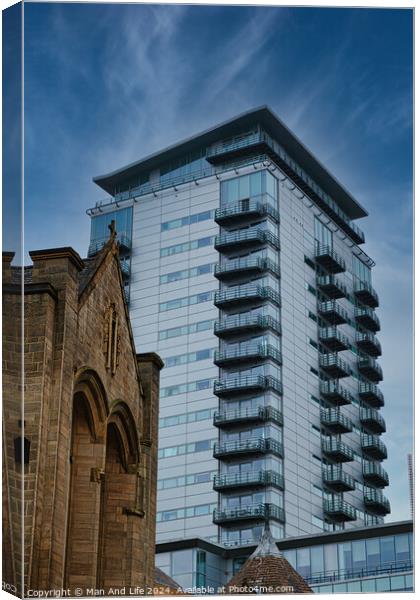 Contrast of old and new architecture with a modern glass skyscraper towering behind a traditional stone church under a clear blue sky in Leeds, UK. Canvas Print by Man And Life
