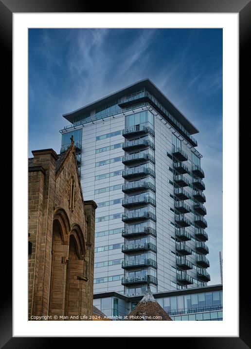 Contrast of old and new architecture with a modern glass skyscraper towering behind a traditional stone church under a clear blue sky in Leeds, UK. Framed Mounted Print by Man And Life