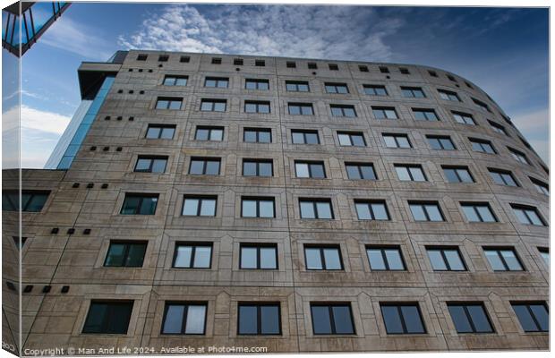 Modern office building facade with geometric windows against a clear blue sky in Leeds, UK. Canvas Print by Man And Life