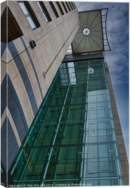 Modern architectural detail with glass facade and clock tower against a blue sky in Leeds, UK. Canvas Print by Man And Life