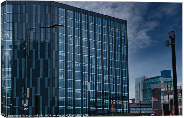 Modern glass office buildings with reflections under blue sky in Leeds, UK. Canvas Print by Man And Life
