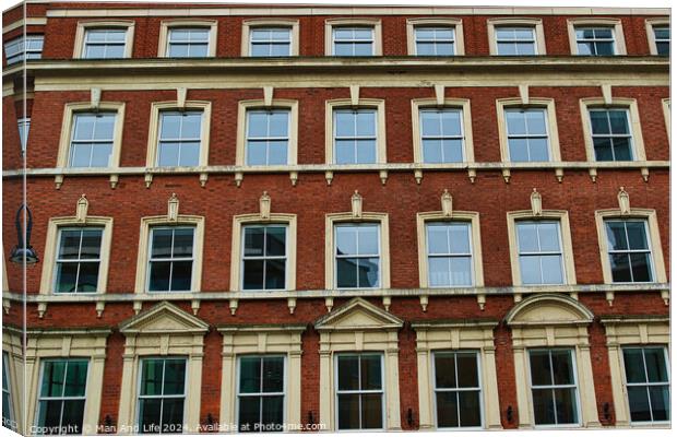 Facade of a classic red brick building with symmetrical windows against a clear sky in Leeds, UK. Canvas Print by Man And Life