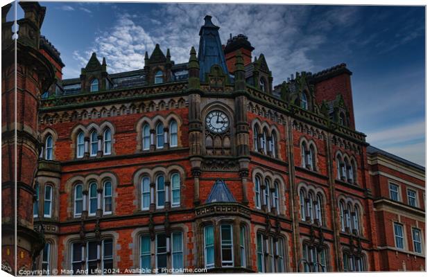 Gothic-style red brick building with clock tower under a moody sky in Leeds, UK. Canvas Print by Man And Life