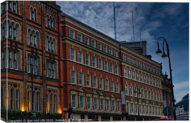 Historic red brick building at dusk with street lamp and dramatic sky in Leeds, UK. Canvas Print by Man And Life