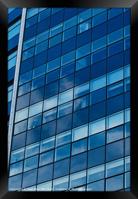 Modern glass building facade reflecting blue sky with clouds, architectural details and textures, urban background in Leeds, UK. Framed Print by Man And Life