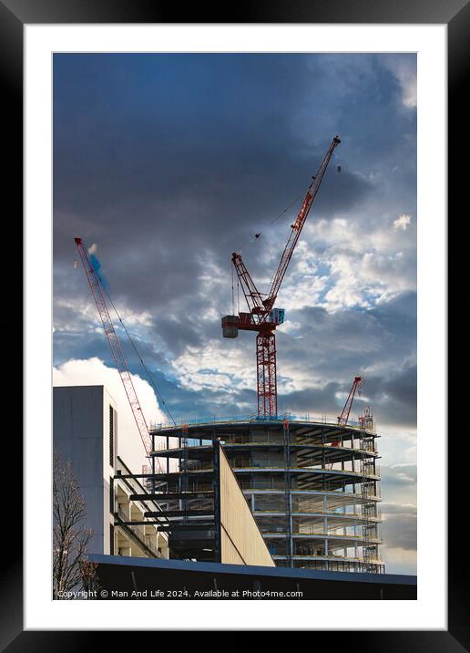 Construction site with cranes against a dramatic cloudy sky, symbolizing development and architecture in Liverpool, UK. Framed Mounted Print by Man And Life