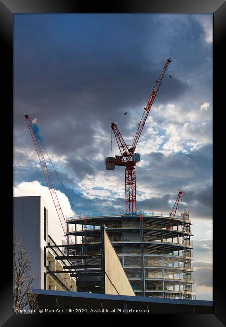 Construction site with cranes against a dramatic cloudy sky, symbolizing development and architecture in Liverpool, UK. Framed Print by Man And Life