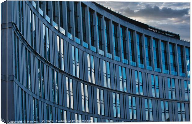 Modern office building facade with reflective glass windows against a cloudy sky at dusk in Liverpool, UK. Canvas Print by Man And Life