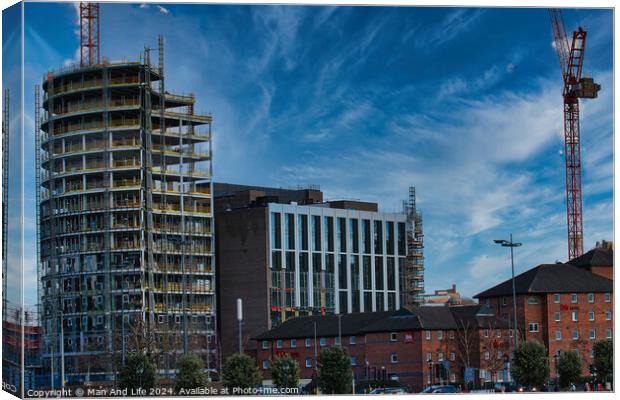 Urban construction site with cranes and developing high-rise building against a blue sky with wispy clouds in Liverpool, UK. Canvas Print by Man And Life