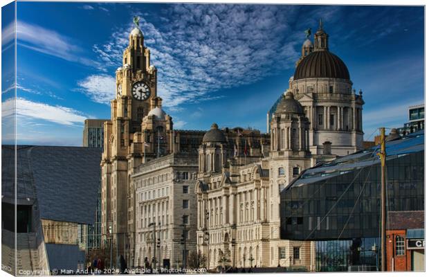 Liverpool's iconic waterfront buildings under a blue sky with wispy clouds. Canvas Print by Man And Life