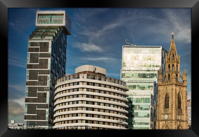 Modern city skyline with a mix of contemporary buildings and a historic church under a blue sky with clouds in Liverpool, UK. Framed Print by Man And Life