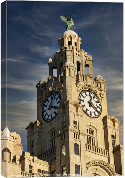 Historic clock tower against a blue sky with clouds, architectural detail, and a statue on top in Liverpool, UK. Canvas Print by Man And Life
