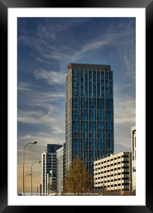 Modern glass skyscraper against a blue sky with clouds, surrounded by urban architecture in Liverpool, UK. Framed Mounted Print by Man And Life