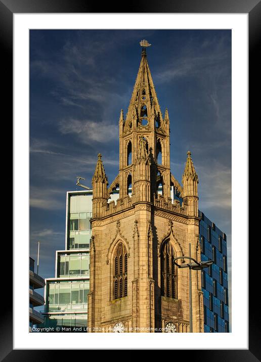 Gothic church spire against a blue sky with modern buildings in the background in Liverpool, UK. Framed Mounted Print by Man And Life