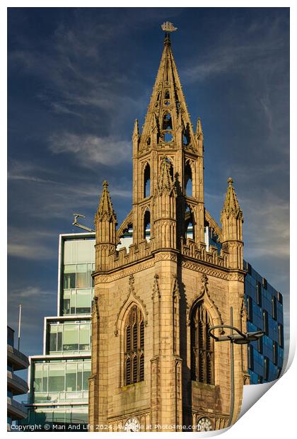 Gothic church spire against a blue sky with modern buildings in the background in Liverpool, UK. Print by Man And Life