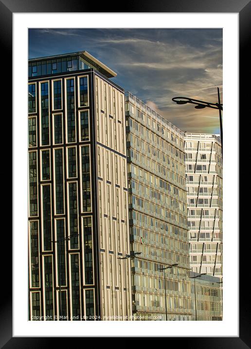 Modern urban architecture with reflective glass facade and contrasting building designs under a blue sky with clouds in Liverpool, UK. Framed Mounted Print by Man And Life