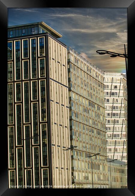 Modern urban architecture with reflective glass facade and contrasting building designs under a blue sky with clouds in Liverpool, UK. Framed Print by Man And Life