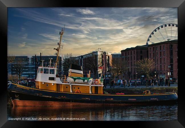 Tugboat in city harbor at sunset with ferris wheel and buildings in background in Liverpool, UK. Framed Print by Man And Life