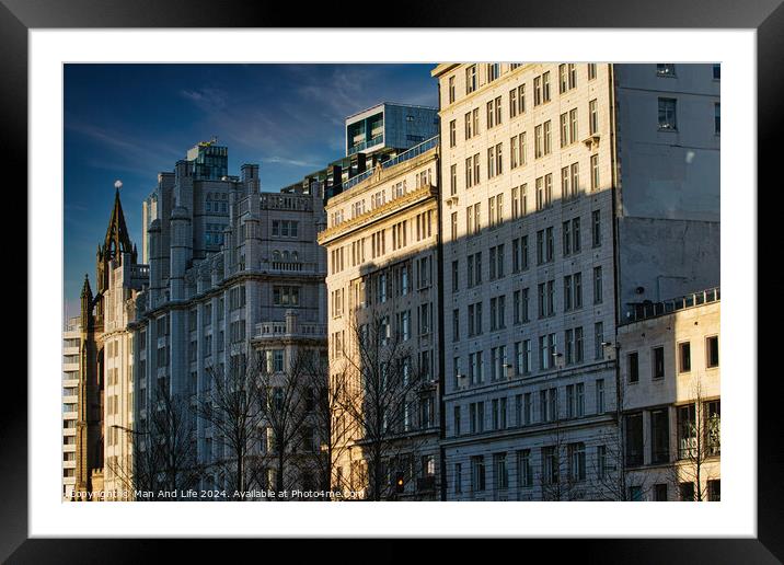 Urban skyline with modern buildings bathed in golden sunlight against a clear blue sky in Liverpool, UK. Framed Mounted Print by Man And Life