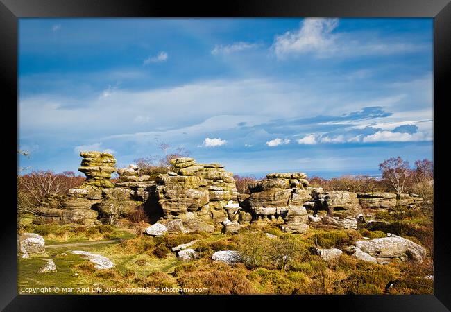 Picturesque rocky landscape with unique rock formations under a blue sky with fluffy clouds at Brimham Rocks, in North Yorkshire Framed Print by Man And Life