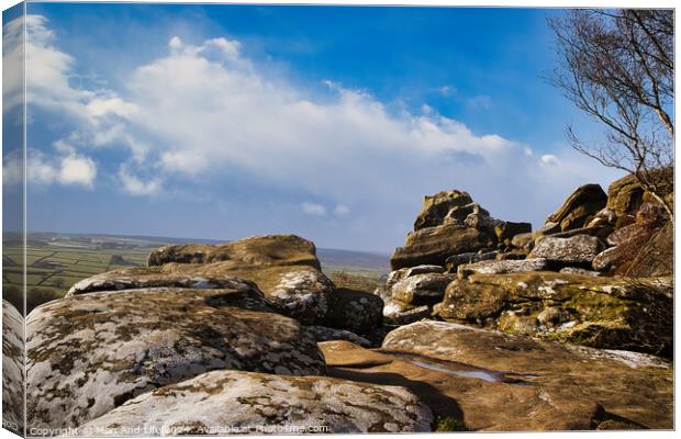 Scenic view of rugged rocks against a blue sky with fluffy clouds, highlighting the natural beauty of a mountainous landscape at Brimham Rocks, in North Yorkshire Canvas Print by Man And Life
