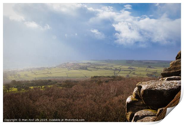 Scenic view of a sunlit countryside landscape with rocky foreground under a dramatic sky at Brimham Rocks, in North Yorkshire Print by Man And Life