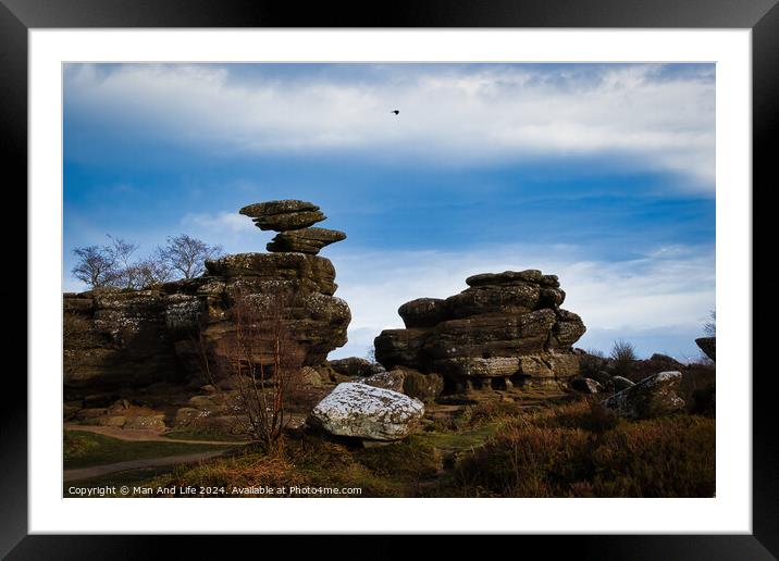 Scenic view of unique rock formations under a blue sky with a solitary bird flying overhead at Brimham Rocks, in North Yorkshire Framed Mounted Print by Man And Life
