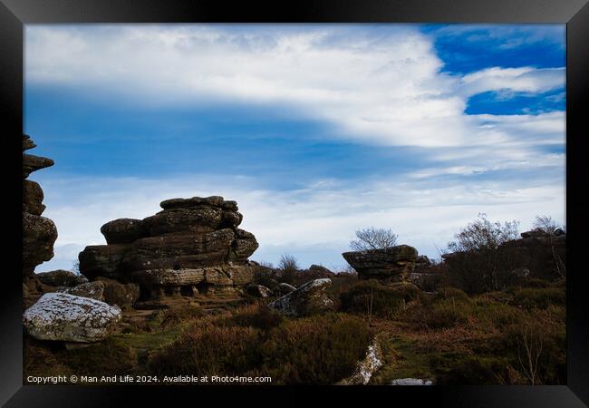Scenic view of rugged rock formations amidst wild heath under a cloudy sky at Brimham Rocks, in North Yorkshire Framed Print by Man And Life